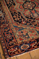 Angled view of a vintage Heriz rug's corner showing the turtle samovar border and hand-knotted pile.