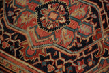 Close-up showing the knot heads and intricate lozenge medallion of a vintage Heriz rug.
