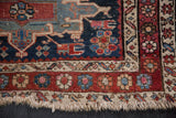 Antique Karaja rug corner with geometric borders, navy field motifs, and distinct fringe tatter.