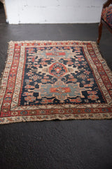 Antique Persian Karaja rug, triple medallion, navy, wine red, ivory, with tattered ends.