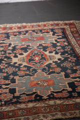 Antique Karaja rug displaying stylized crab motifs, geometric patterns, and worn fringe.