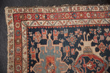 Antique Karaja rug corner with navy field, crab motifs, red borders, tattered edge.