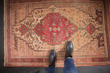 Vintage Farahan Sarouk with a bold cherry red medallion on an ivory floral field.