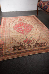 Delicate floral vines, dark cherry, and charcoal motifs on this vintage Farahan Sarouk rug.