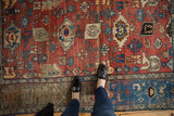 Vintage Bijar rug's cherry red field with dramatic abrashes and Harshang flower motif.