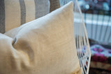 Neutral linen fabric texture on a lumbar pillow, featuring a fine herringbone weave.