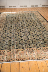 Distressed Oushak rug with black, pale apricot, ivory floral palmettes and geometric border.