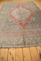 Textured fringe and faded border with raspberry blush and pale bronze on the Oushak rug.