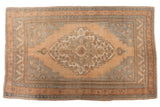 Vintage distressed Oushak carpet, large medallion with soft sandalwood and slate blue floral patterns.