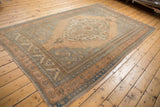 Distressed vintage Oushak rug, scalloped medallion, intricate floral motifs in apricot and slate blue.