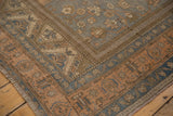 Low pile corner of a distressed Oushak rug with apricot, slate blue, and bronze floral borders.