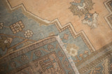 Vintage Oushak rug corner with distressed pale apricot, slate blue pile and knotted reverse.