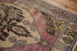 Distressed vintage Oushak runner detail, showing mauvy field with wear to knot heads.