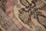 Distressed Oushak runner with mauvish-pink, beige, brown tones and visible foundation.