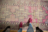 Distressed Oushak runner with faded mauve and gold stepped medallion and serrated leaf border.