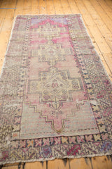 Distressed pile texture on a vintage Oushak rug, highlighting worn fringe and geometric patterns.