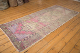 Distressed Oushak runner close-up: textured pile, serrated border, mauve and blue tones.