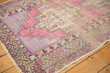 Distressed Oushak runner corner with white fringe and geometric serrated leaf border pattern.