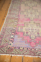 Softened texture and geometric border on distressed mauvy pink Oushak runner.
