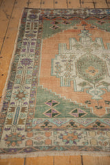 Distressed pile and colorful floral palmette border on a vintage Oushak rug corner.