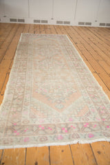 Distressed Oushak runner showcasing Rococo-inspired floral designs in pale peach, ivory, and bright pink.
