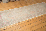 Distressed texture and faint pale peach motifs on a vintage Oushak rug runner corner.