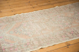 Distressed Oushak runner's texture, revealing mostly even wear, faint foundation, bright pink floral elements.