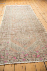 Distressed Oushak runner end, bright pink floral border, white fringe, mostly even pile wear.