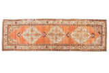 Distressed vintage Oushak runner with ivory sharp contour medallions on an abrashed terra cotta field.