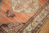Distressed Oushak runner with abrashed terra cotta field and ornate scrolling floral border.