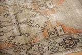 Textural close-up of distressed Oushak rug runner showing foundation wear and serrated motifs in rust and brown.