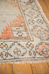 Fringe and distressed pile of vintage Oushak rug with beige, terra cotta, and brown motifs.