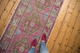 Distressed Oushak runner, faded pink pile, faint foundation, geometric floral motifs.