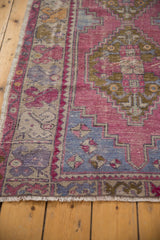 Distressed Oushak runner border, showing worn aubergine, blue, and bronze floral geometric patterns.