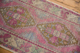 Stepped geometric outline and floral border of a vintage distressed Oushak rug.