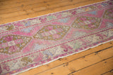 Pink distressed Oushak runner with geometric floral patterns and faint foundation showing through.