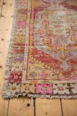 Distressed texture and playful pink, red, saffron floral motifs on a vintage Oushak rug.