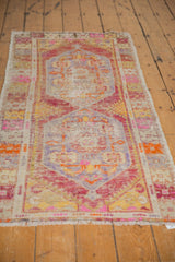 Distressed Oushak runner end with fringe and faded floral motifs in blush pink, tangerine.