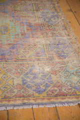 Distressed hand-knotted Oushak rug pile, featuring muted mauve, pale green, and dusty gold.