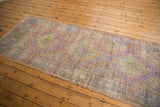 Distressed Oushak runner displaying muted mauve, time-softened green, and dusty gold hues.