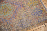 Distressed Oushak runner: royal mauve, pale oxidized green, dusty gold tones, visible pile wear.
