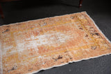 Vintage distressed Oushak rug in warm gold, sand, and ivory tones with rich texture.