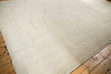Vintage distressed Oushak carpet, subtle tone-on-tone patterns in ivory, beige, showing wear.