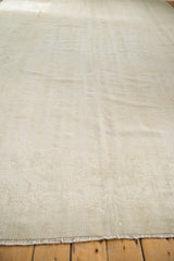 Distressed Oushak rug's ivory end fringe and hand-knotted pile showing visible knot heads.