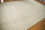 Distressed vintage Oushak rug with soft ivory and beige tones, faint Rococo pattern.