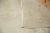 Secured edge, hand-knotted foundation, and faded processing number on the Oushak rug.