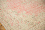 Textured distressed Oushak rug border in blush pink and pale beige, showing even wear.