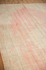 Textural focus on the distressed Oushak carpet, blending blush, pink, and beige with soft wear.