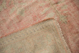 Distressed vintage Oushak rug showing its blush pile worn to the beige foundation.