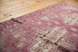 Distressed pile texture of a vintage Oushak rug showing aubergine and ivory stepped patterns.